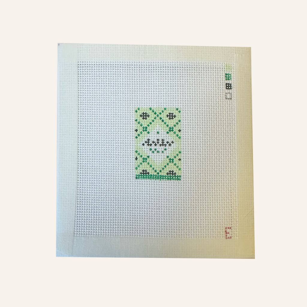 A needlepoint canvas featuring a flakey sea salt box pattern. The pattern is miniaturized so "text" is indiscernible but still conveys the pattern. The canvas features a color palette panel and is signed by "E"
