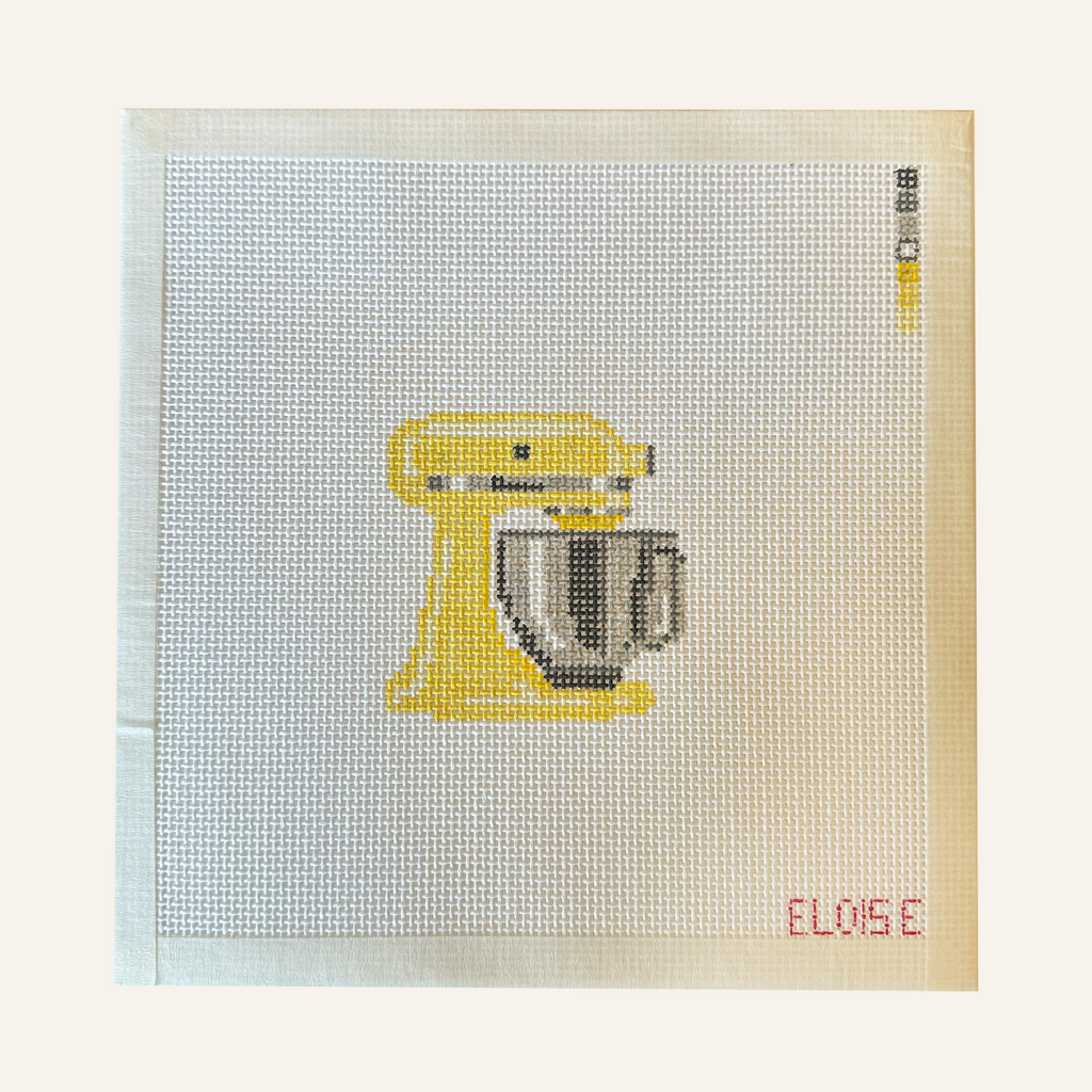 needlepoint canvases featuring a stand mixer pattern in yellow. The canvases feature a color palette panel and is signed by "Eloise."