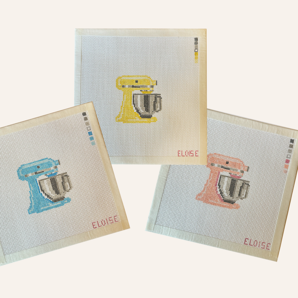 Three needlepoint canvases featuring a stand mixer pattern in pink, blue or yellow. The canvases feature a color palette panel and is signed by "Eloise."