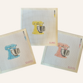 Three needlepoint canvases featuring a stand mixer pattern in pink, blue or yellow. The canvases feature a color palette panel and is signed by "Eloise."
