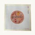 A Griffindor needlepoint canvas designed as a red circle with Griffindor motifs. the canvas has a color palette guide and is signed "Eloise"